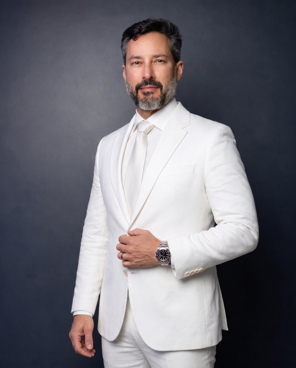 Dr. Stanley Bittar em retrato editorial, terno claro, luz quente lateral